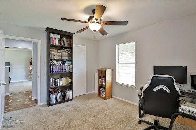 carpeted home office featuring ceiling fan