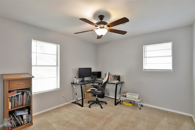 office area with ceiling fan, light colored carpet, and plenty of natural light