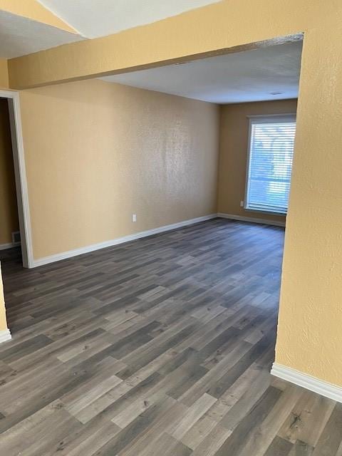 spare room featuring dark wood-type flooring