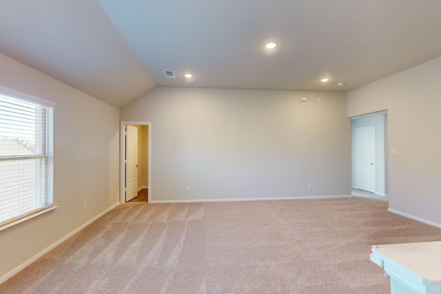 empty room featuring lofted ceiling and light carpet