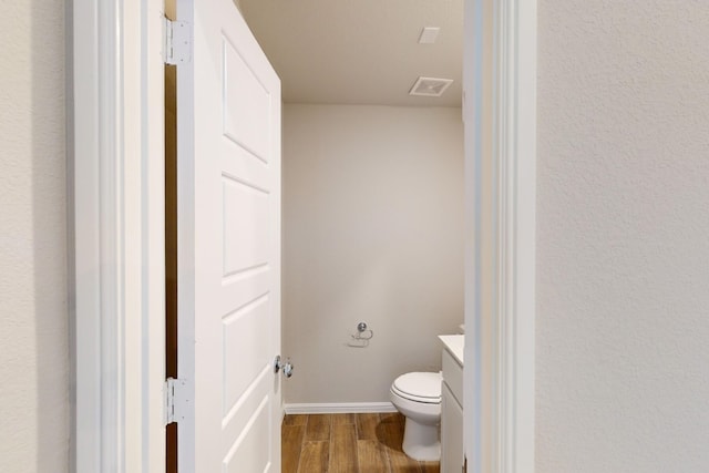 bathroom featuring vanity, hardwood / wood-style flooring, and toilet