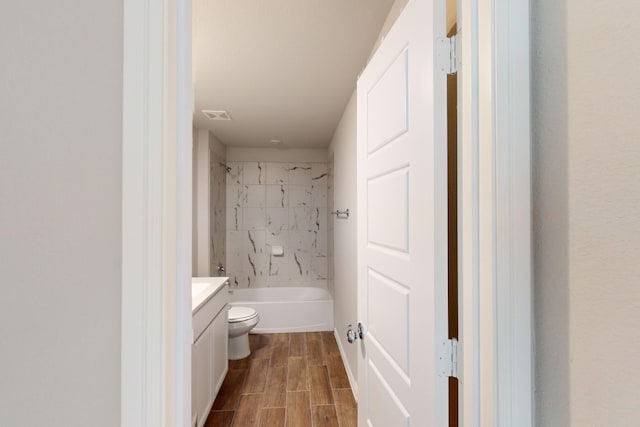 full bathroom featuring toilet, tiled shower / bath combo, and vanity