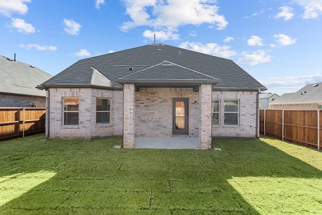 back of property with a yard and a patio area