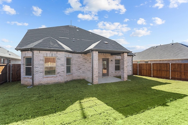 rear view of house featuring a patio and a yard