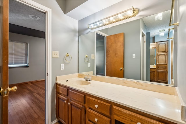 bathroom featuring vanity, a textured ceiling, and hardwood / wood-style flooring