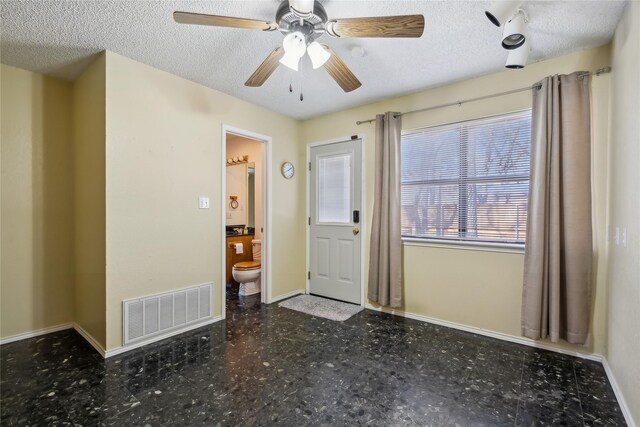 foyer with a textured ceiling and ceiling fan