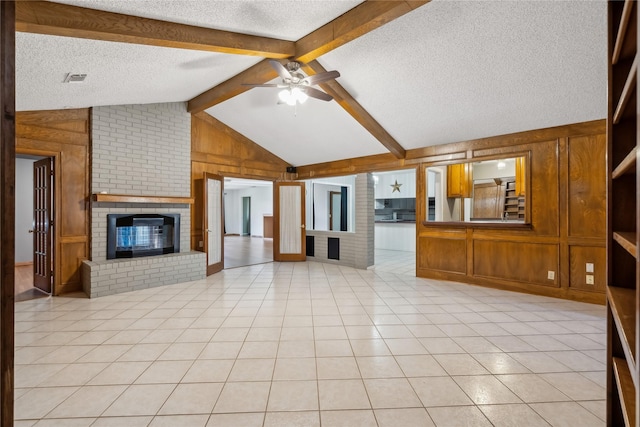 unfurnished living room featuring light tile patterned floors, lofted ceiling with beams, ceiling fan, and wooden walls