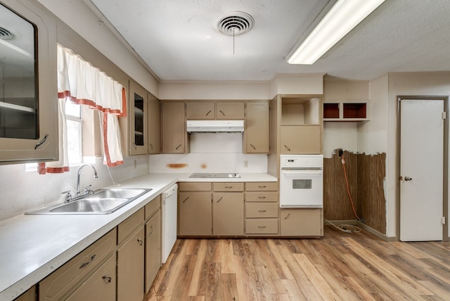 kitchen featuring white appliances, a textured ceiling, light hardwood / wood-style floors, and sink