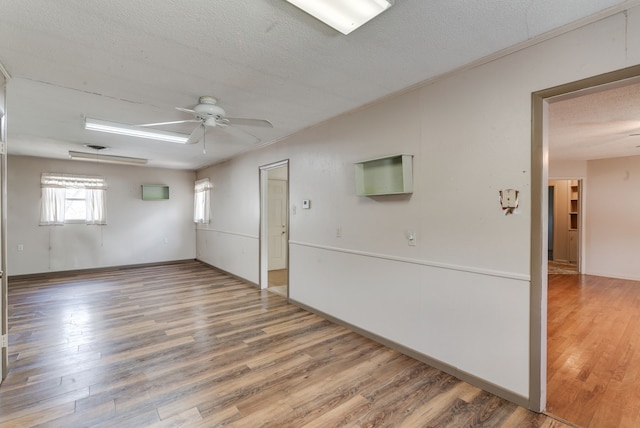 empty room featuring a textured ceiling, ceiling fan, and hardwood / wood-style floors