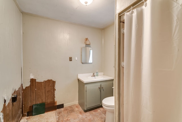 bathroom with toilet, ornamental molding, and vanity