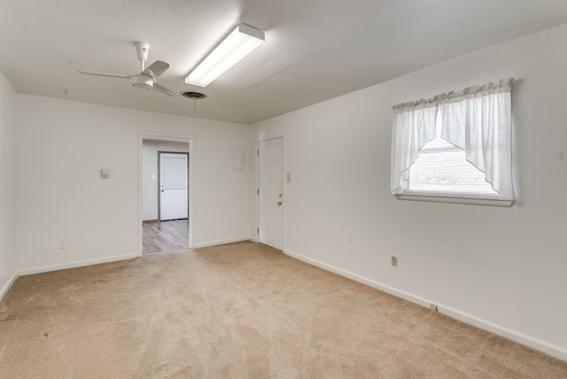 unfurnished room with ceiling fan and light colored carpet