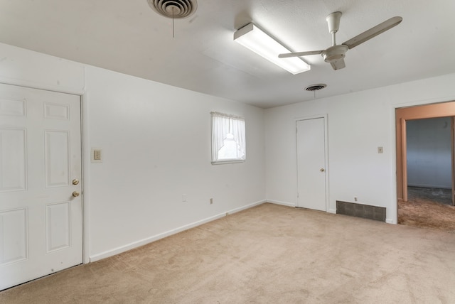 spare room with ceiling fan and light colored carpet