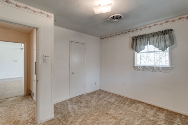 unfurnished bedroom with a closet and light carpet