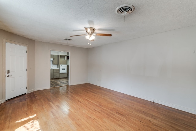 unfurnished room featuring light wood-type flooring, ceiling fan, and a textured ceiling