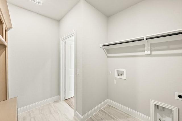 clothes washing area with light hardwood / wood-style floors, hookup for a gas dryer, electric dryer hookup, and hookup for a washing machine