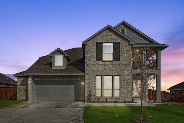 view of front of home featuring a balcony, a garage, and a lawn