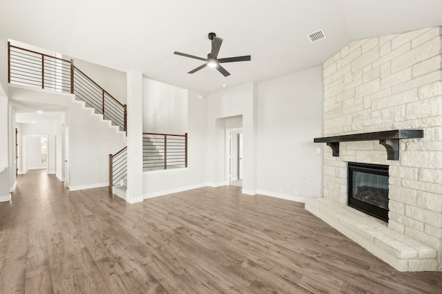 unfurnished living room featuring a fireplace, ceiling fan, and wood-type flooring