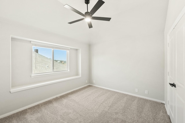 carpeted spare room featuring ceiling fan