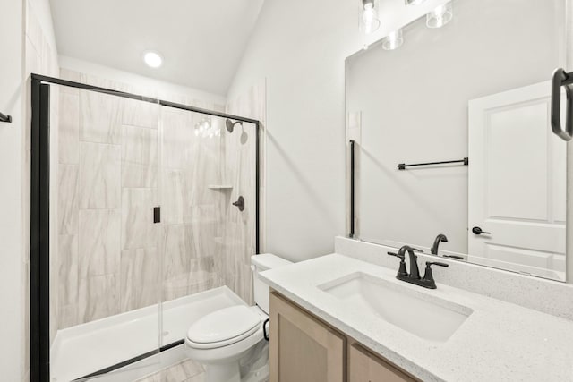 bathroom featuring toilet, vaulted ceiling, a shower with shower door, and vanity