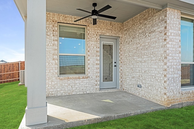 view of exterior entry featuring ceiling fan, a patio, and central AC unit