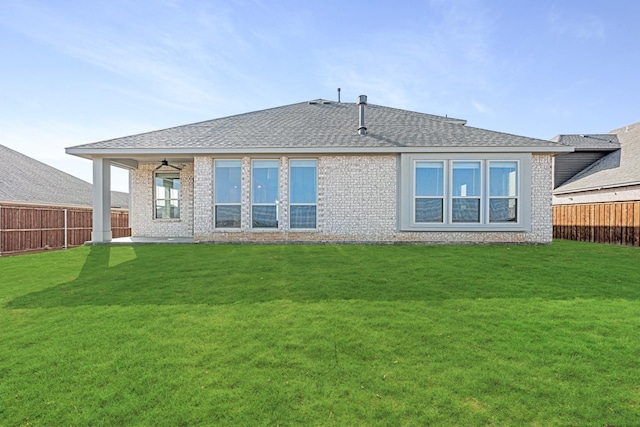 back of house featuring a lawn and ceiling fan