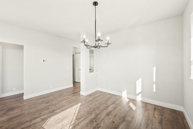 unfurnished dining area with hardwood / wood-style flooring and a notable chandelier