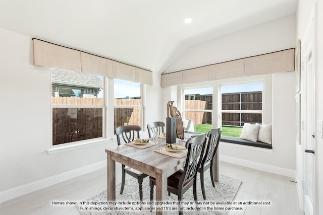 dining area featuring lofted ceiling, light hardwood / wood-style floors, and a healthy amount of sunlight