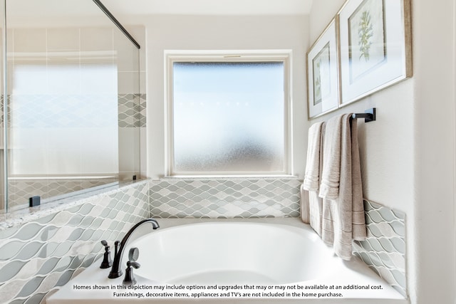 bathroom with a tub to relax in and plenty of natural light