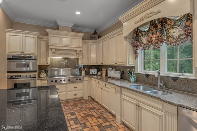 kitchen with decorative backsplash, cream cabinets, appliances with stainless steel finishes, and sink