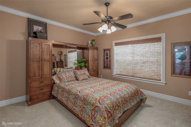 carpeted bedroom featuring crown molding and ceiling fan