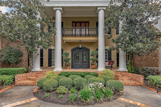 view of front facade featuring a balcony and french doors