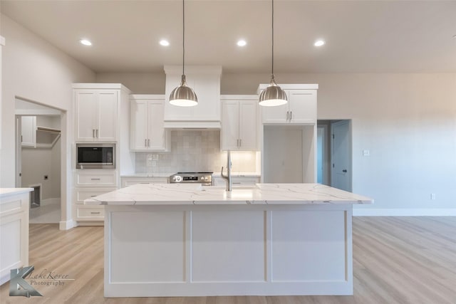 kitchen with appliances with stainless steel finishes, a sink, white cabinets, and decorative backsplash