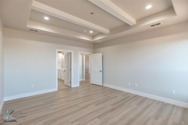 unfurnished bedroom with a tray ceiling and visible vents