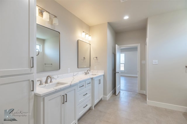 full bathroom featuring double vanity, baseboards, a sink, and recessed lighting