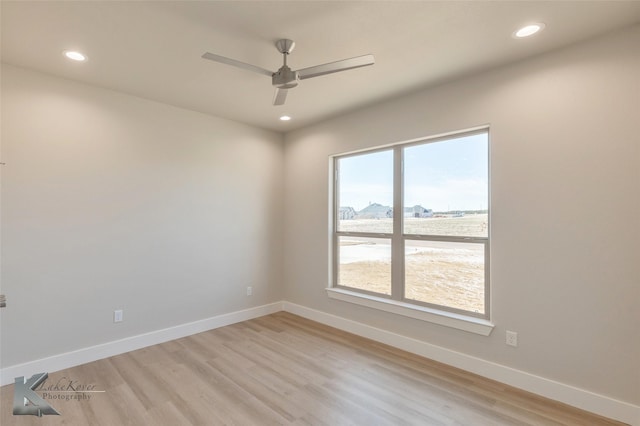 empty room with light wood-style flooring, baseboards, and recessed lighting