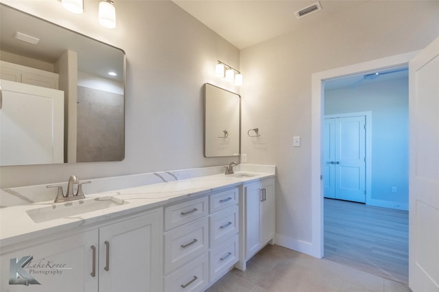 bathroom featuring double vanity, baseboards, visible vents, and a sink