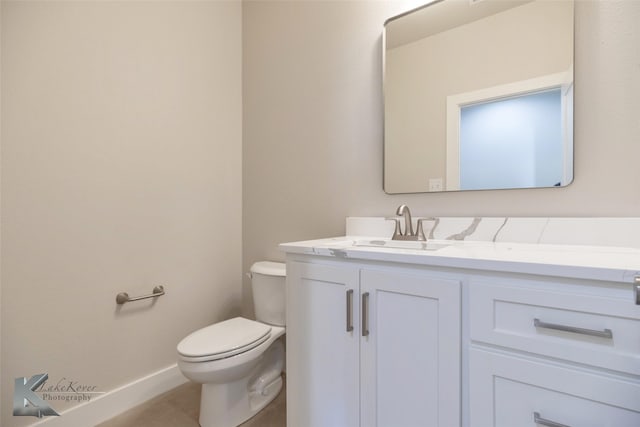 bathroom with toilet, baseboards, vanity, and tile patterned floors