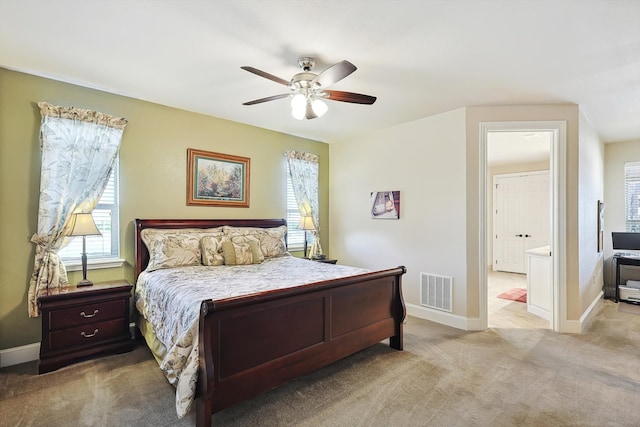 bedroom featuring ceiling fan, multiple windows, and light carpet