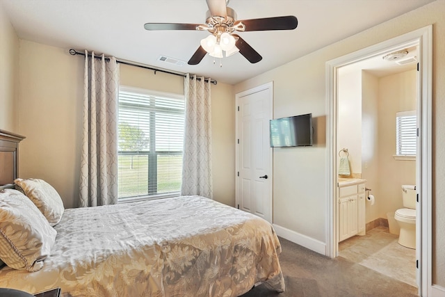 bedroom with ensuite bathroom, ceiling fan, and light carpet