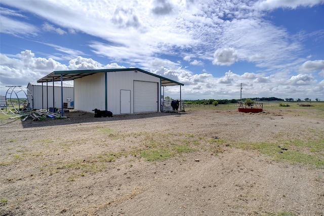 view of outdoor structure with a garage and a rural view