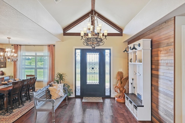 foyer with dark wood-type flooring, an inviting chandelier, and vaulted ceiling with beams