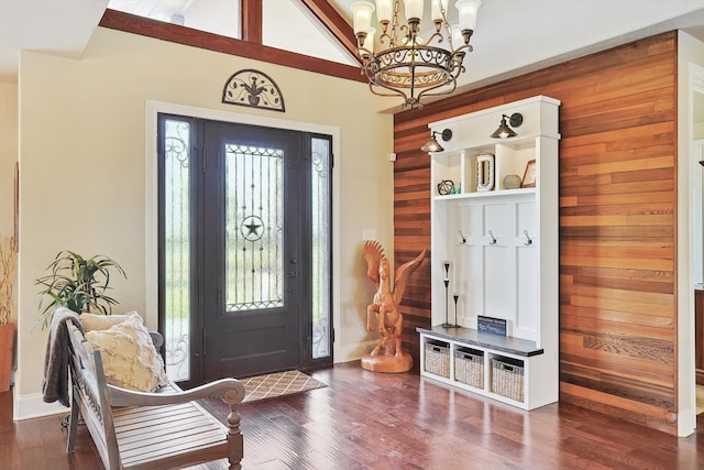 foyer entrance with a chandelier, wooden walls, vaulted ceiling with beams, and dark hardwood / wood-style floors