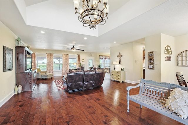 living room with dark hardwood / wood-style floors and ceiling fan with notable chandelier