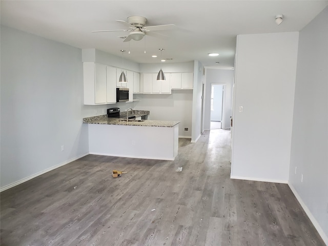 kitchen with white cabinetry, kitchen peninsula, light stone countertops, light wood-type flooring, and ceiling fan