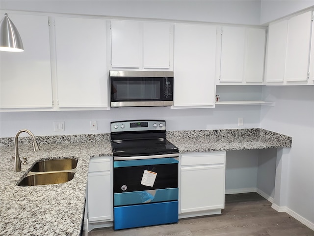 kitchen featuring light wood-type flooring, sink, white cabinetry, appliances with stainless steel finishes, and light stone countertops