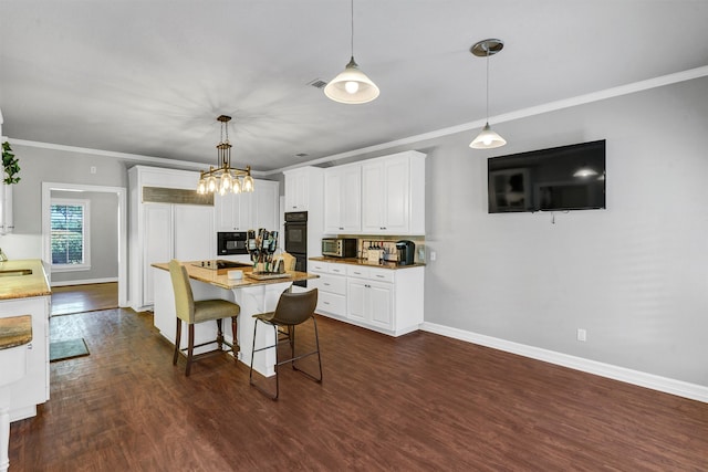 kitchen featuring pendant lighting, white cabinetry, a kitchen bar, and dark hardwood / wood-style floors