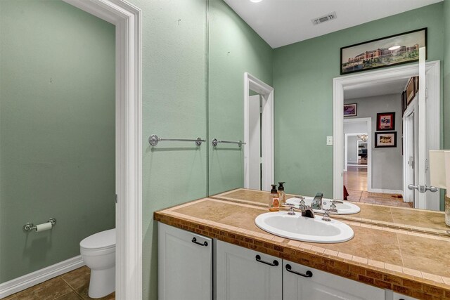 bathroom featuring tile patterned floors, vanity, and toilet