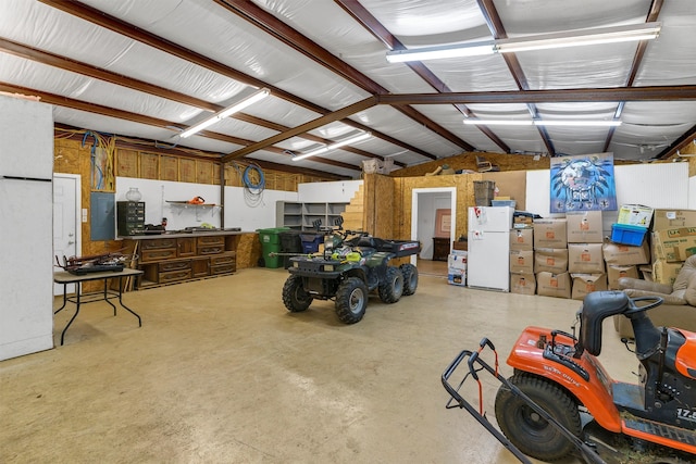 garage featuring electric panel and white refrigerator