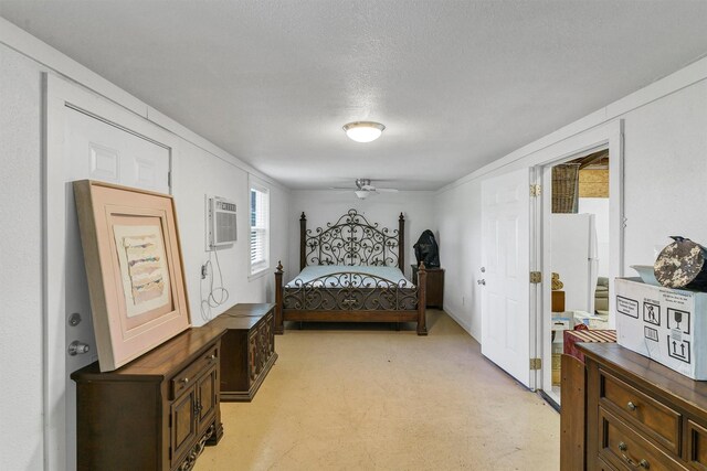 bedroom featuring a textured ceiling, a wall mounted air conditioner, and white refrigerator