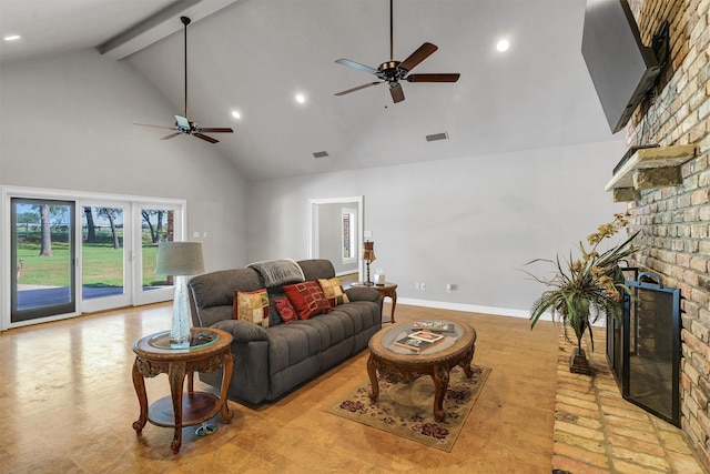 living room featuring ceiling fan, beamed ceiling, a fireplace, and high vaulted ceiling